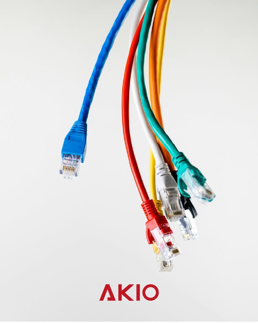 Faisceau de câbles réseau colorés au-dessus du logotype AKIO, visuel de communication.